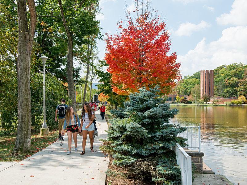 Students walking to and from class by the campus reflecting pond